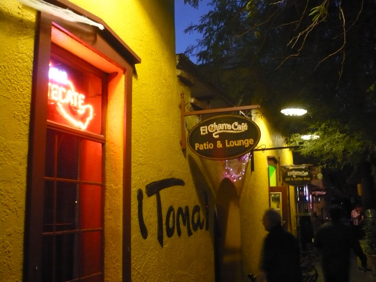 Lit patio and lounge sign outside El Charro Café in Tucson at night