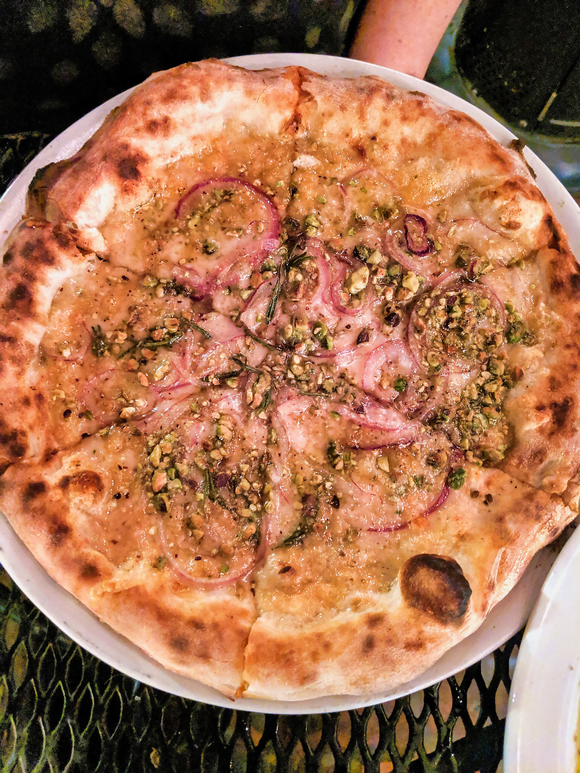 A wood-fired pizza topped with red onion, chopped pistachios and rosemary at Pizzeria Bianco in Phoenix