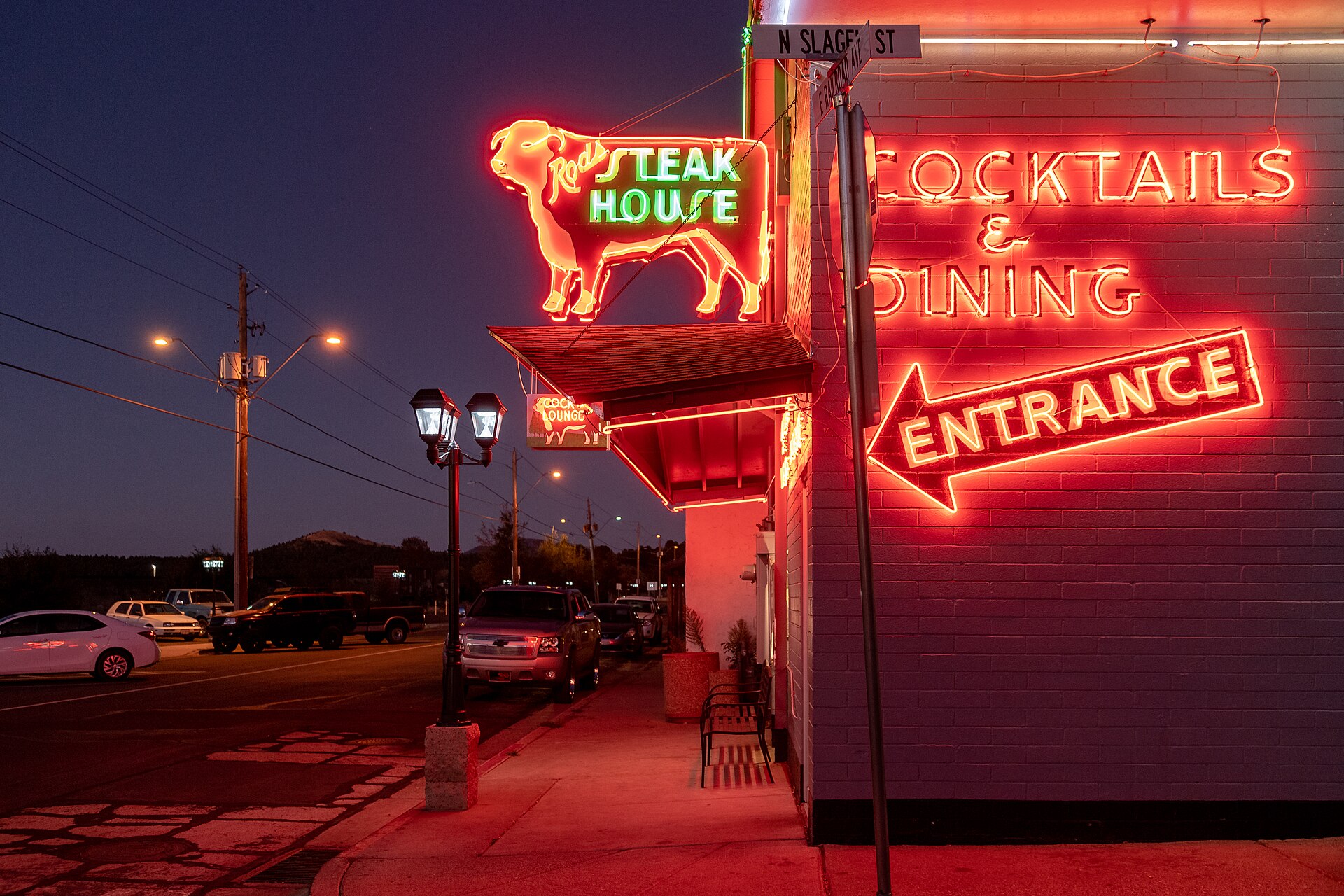 Red neon glowing at the entrance of Rod's Steak House in Williams, Arizona, at night