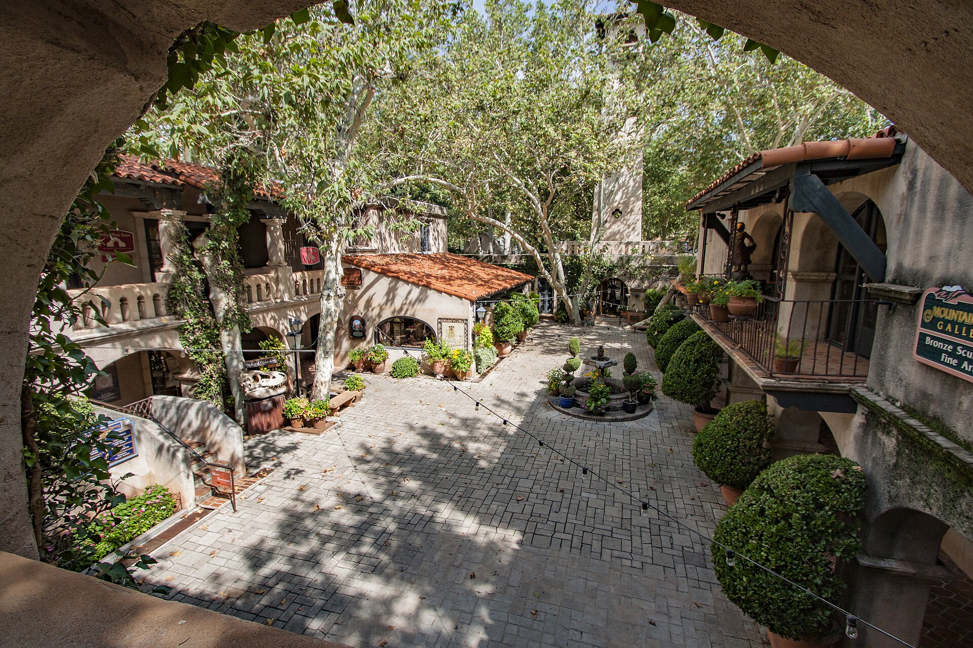 Stucco shops, arches and trees inside Tlaquepaque Arts and Shopping Village in Sedona